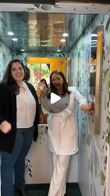 Duas profissionais na entrada da Q!Clinic, ao lado de um painel de plantas