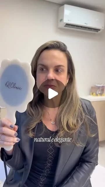 Profissional da Q!Clinic segurando um espelho com a marca da clínica