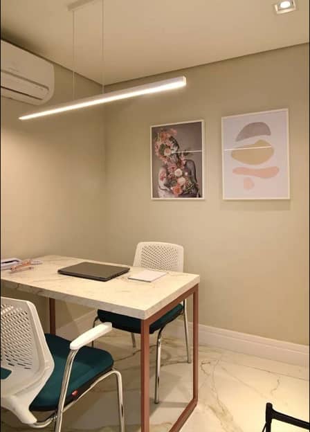 Sala de avaliação da Q!Clinic, com mesa, cadeiras e quadros em tons claros