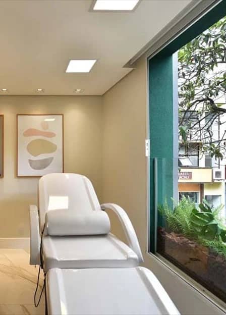 Sala de tratamento da Q!Clinic, com poltrona reclinável e vista para o jardim